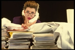Businesswoman with stacks of paperwork